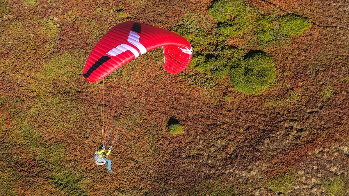 ozone-geo-7-red-glider-against-mountain-with-halo-harness ozone-geo-7-red-glider-against-mountain-with-halo-harness