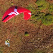 ozone-geo-7-red-glider-against-mountain-with-halo-harness